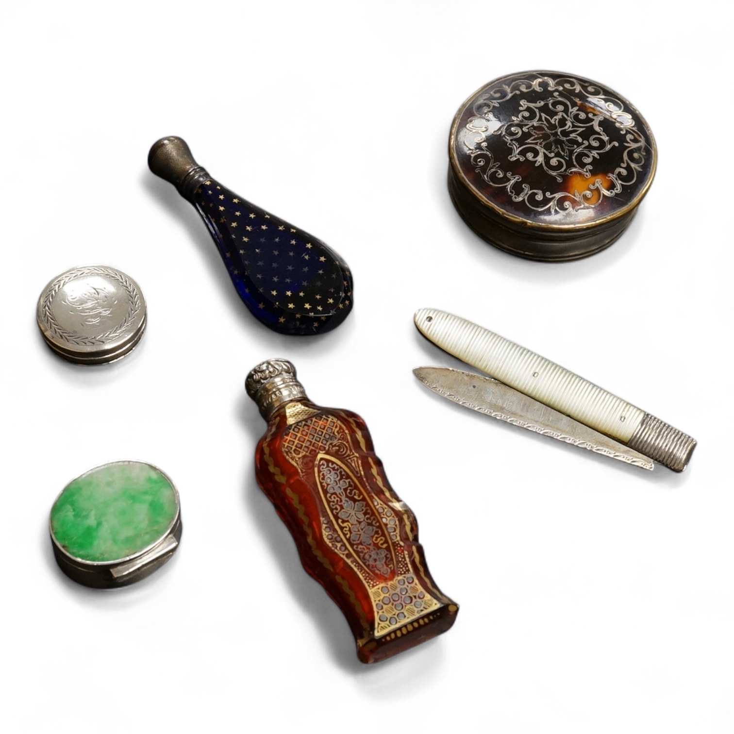 A collection of 19th century and later silver and white metal mounted items comprising three boxes, two glass scent bottles and a folding mother of pearl pen knife, largest 7.5cm high